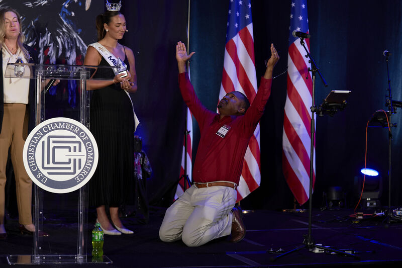 Bristan Heaven kneeling in worship on stage