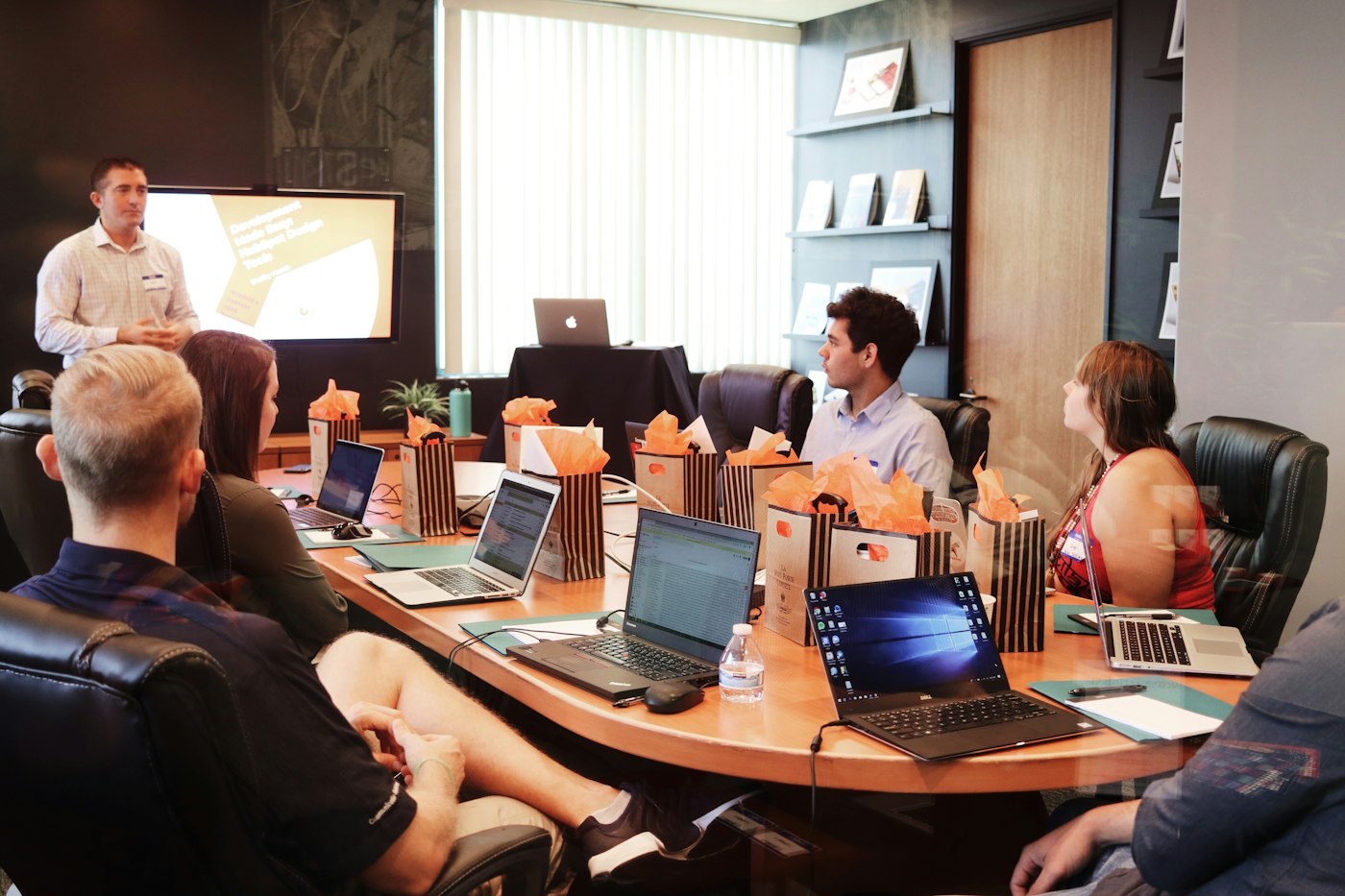 A leader presenting to a seated team in a boardroom
